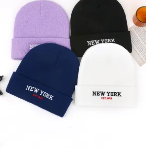 Vista detallada del gorro de punto de invierno con bordado New York, tela suave y ajuste cálido.