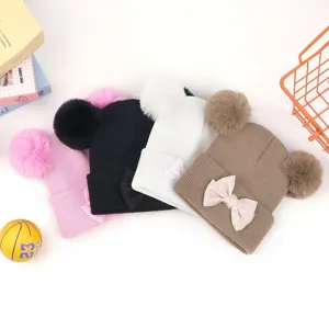 Joli bonnet tricoté pour bébé avec double pompons et nœud, bonnet chaud d'hiver pour enfants.