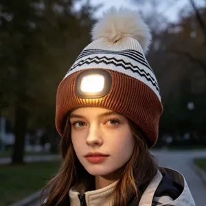 Warm winter knitted beanie hat with built-in LED headlamp, pompom, brown and white pattern.