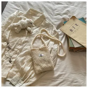 Gros plan detaille d'un sac bandouliere mini en tricot douillet dans un style de vie.