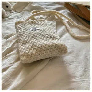 Vue détaillée sac bandoulière en tricot, petit sac téléphone beige décontracté, accessoire.