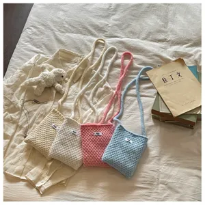 Vue détaillée du mini sac bandoulière tricoté aux couleurs bonbon avec texture douce.