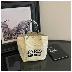 Vista di dettaglio di una borsa secchiello in maglia beige con manici pied de poule.