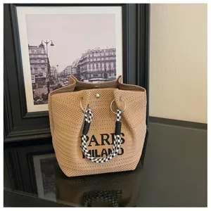 Vista dettagliata dell'elegante borsa shopper in maglia beige con manici in corda bianchi e neri.