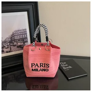 Elegante borsa a secchiello in maglia rosa con manico pied de poule, accessorio alla moda.