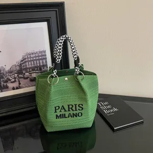 Elegante borsa a secchiello in maglia verde con manico pied-de-poule e design tessuto Paris Milano.