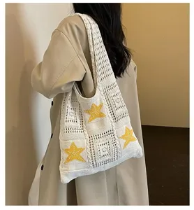Charmant sac cabas de plage en tricot avec des motifs d'étoiles jaunes et un design crocheté.