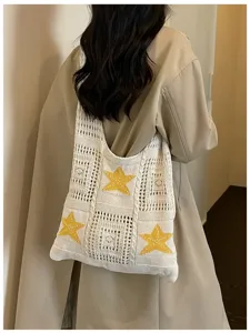 Gros plan détaillé du sac à épaule en tricot tendance avec de jolies étoiles jaunes.