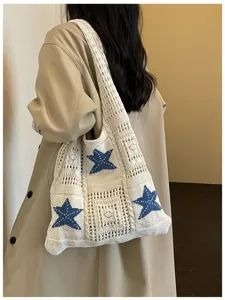 Vue détaillée du sac bandoulière en tricot avec des motifs d'étoiles bleues pour la plage.