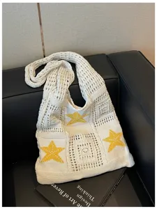 Sac bandoulière en tricot beige avec motifs d'étoiles jaunes pour les vacances à la plage.