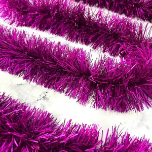Close-up detail of fuchsia metallic tinsel garland, thick and fluffy holiday decor.