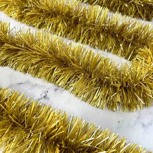 Gold tinsel garland for Christmas party decoration, shiny metallic ribbon hanging decor.
