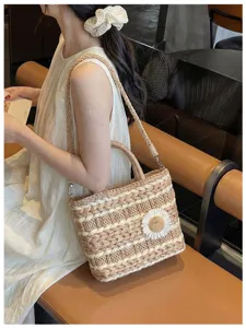 Woven straw handbag detail showing delicate braided texture and cute daisy flower decoration.