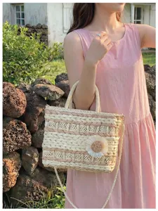Woven straw handbag detail showing intricate braided texture and cute floral decoration feature.