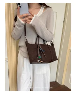 Minimalist retro brown suede shoulder bag for women, chic commuting crossbody dumpling bag with charms.