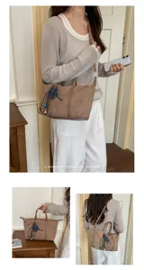 Stylish suede dumpling shoulder bag for women, retro casual commuter crossbody bag with charm.