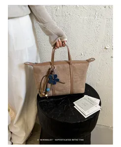Minimalist suede handbag for women, chic retro shoulder tote bag with floral pendant charm.