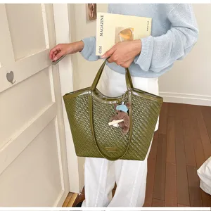 Detailed view of dark green woven tote bag showcasing premium texture and cute bear pendant.