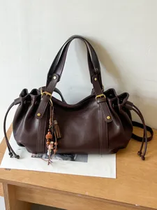 Borsa a spalla morbida in pelle marrone scuro classica con coulisse e nappa chic.