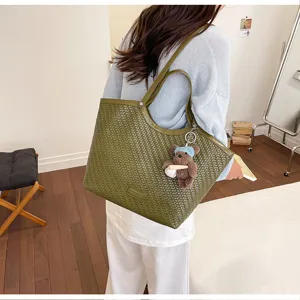 Detailed view of the woven textured large capacity shoulder tote bag with cute bear charm.