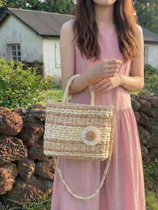 Woven straw handbag for women, stylish shoulder crossbody basket bag with floral decor.