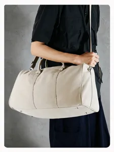 Detail view of canvas duffel travel bag showing durable fabric and sturdy shoulder strap.