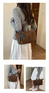 Retro brown suede shoulder bag for women, minimalist daily tote with cute blue flower charm.