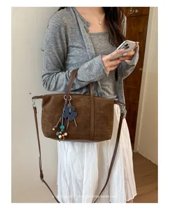 Brown suede dumpling shoulder bag detailed view showcasing retro aesthetic and chic charm.