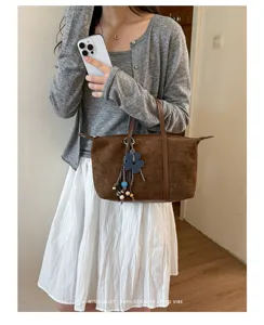 Korean vintage brown suede dumpling tote bag with chic flower pendant for daily commuting.
