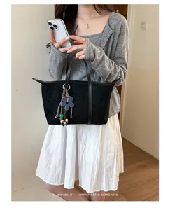 Black suede dumpling tote bag detail, minimalist retro style shoulder handbag for women.