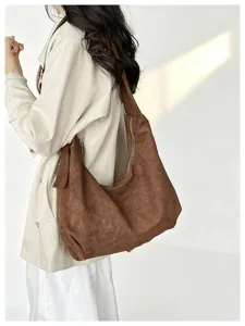 Braune Wildleder Beuteltasche Detail, weiche Textur Vintage Hobo Nahaufnahme Ansicht.