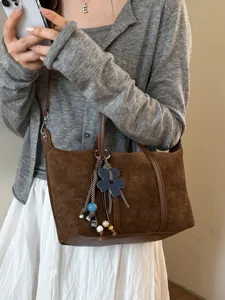 Brown suede dumpling shoulder bag for women, stylish commuting tote with chic floral charm.