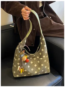 Detailed close-up view of vintage suede polka dot hobo shoulder bag with playful charms.