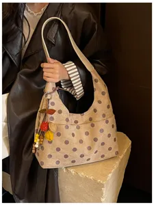 Vintage polka dot suede shoulder bag detail, showcasing soft texture and stylish fruit charm.