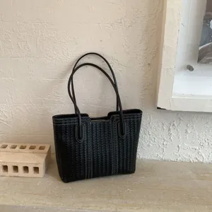 Black woven leather tote bag detail view, showing exquisite intrecciato craftsmanship and texture.