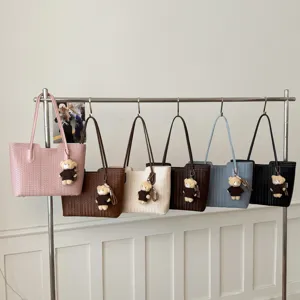Stylish woven tote bag for women, large capacity shoulder handbag with cute bear pendant.
