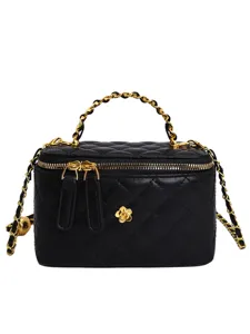 Black quilted leather vanity box bag with gold chain handle and crossbody strap.