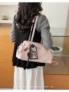 Dettaglio di borsa a spalla rosa con design elegante e ciondolo carino per l'uso quotidiano.
