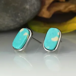 Gros plan détaillé de boucles d'oreilles puces turquoise géométriques en argent sterling 925.