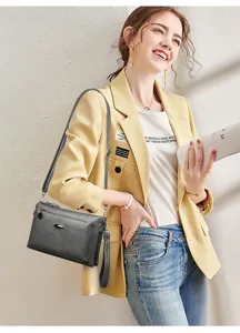 Stylish multi-layer PU leather crossbody shoulder bag with metal accent and adjustable strap.