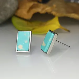 Boucles d'oreilles clous argent pierre turquoise rectangulaire, détail mode bijoux élégants.