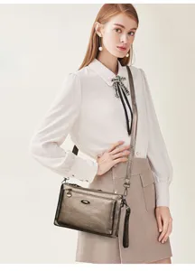 Detailed view of the elegant metallic shoulder bag worn by a model in a studio setting.