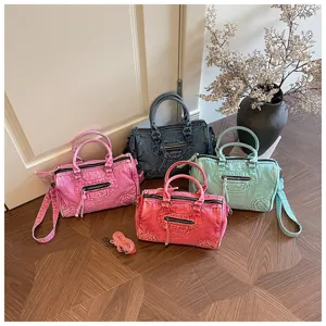 Detail view of stylish washed denim motorcycle bags in multiple vibrant colors with metal zippers.