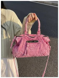 Pink washed denim motorcycle shoulder handbag detail view with metal zippers and straps.