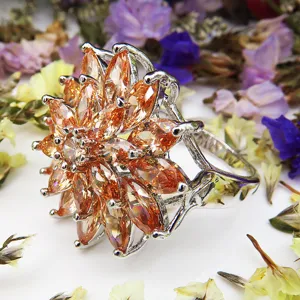 Detailopname van een prachtige bloemring met sprankelende oranje zirkoonstenen en zilver.