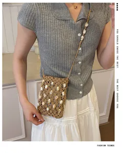 Dettaglio borsa per telefono mini perlinata intrecciata a mano, stile borsa a tracolla chic.