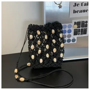 Vista dettagliata della borsa a tracolla mini intrecciata nera con eleganti perline beige.