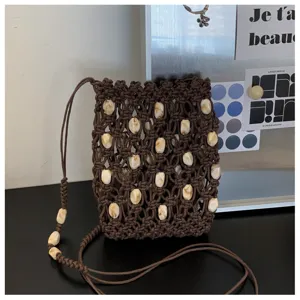 Dettaglio borsa mini intrecciata marrone, vista ravvicinata del design elegante con perline.
