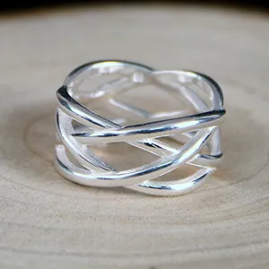 Silver woven ring close up detail, intricate interlaced lines design, elegant jewelry.