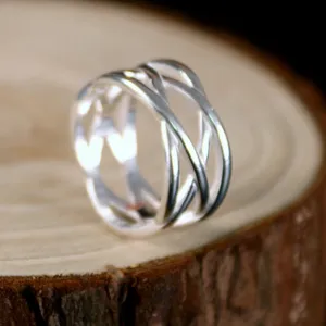 Detail shot of silver interlaced woven ring showing exquisite hollow geometric metal texture.